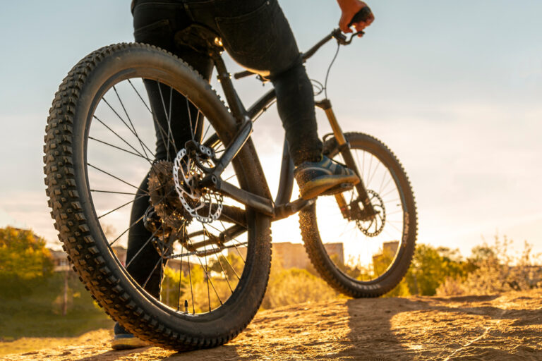 Low angle view of cyclist riding mountain bike. Foot on pedal.