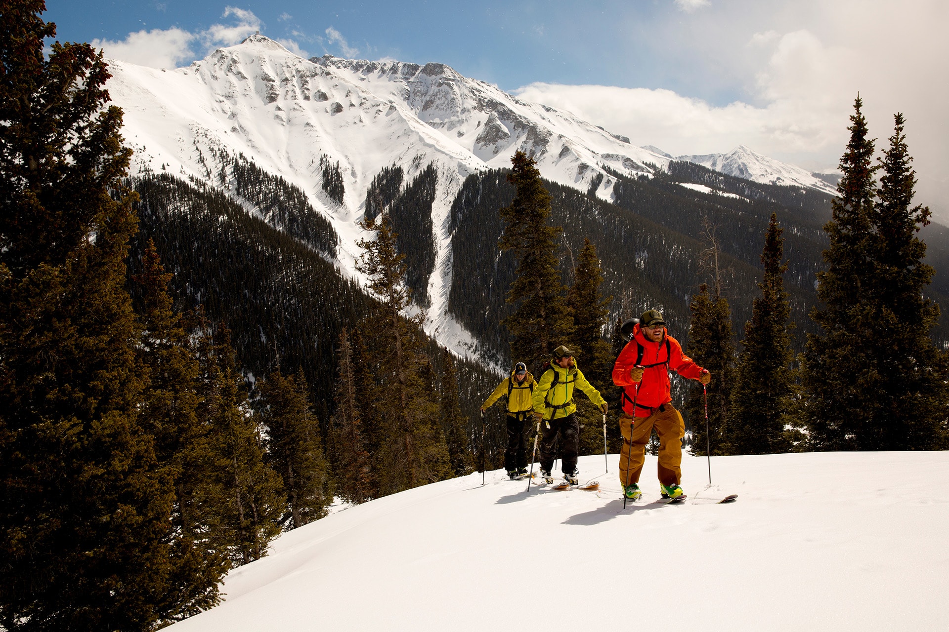 Group of three skiers ascending snowy Colorado mountain