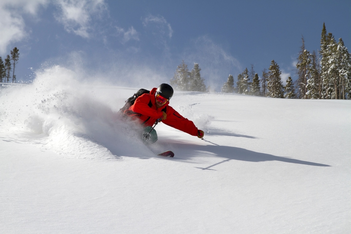 Skier carving through fresh snow on Colorado mountain
